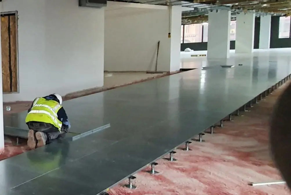 BJM Flooring installer fitting raised access floor panels on pedestals